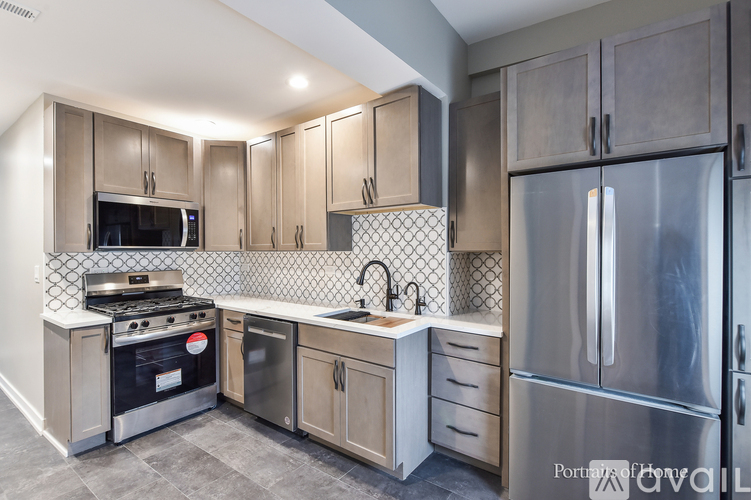 A kitchen with a stainless steel refrigerator, microwave, oven, and sink.