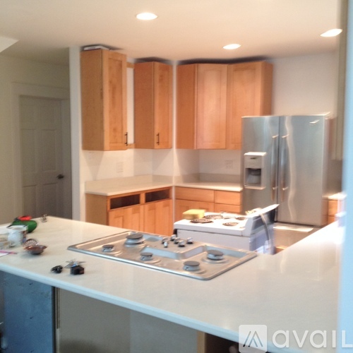 A kitchen with wooden cabinets and a stainless steel refrigerator.