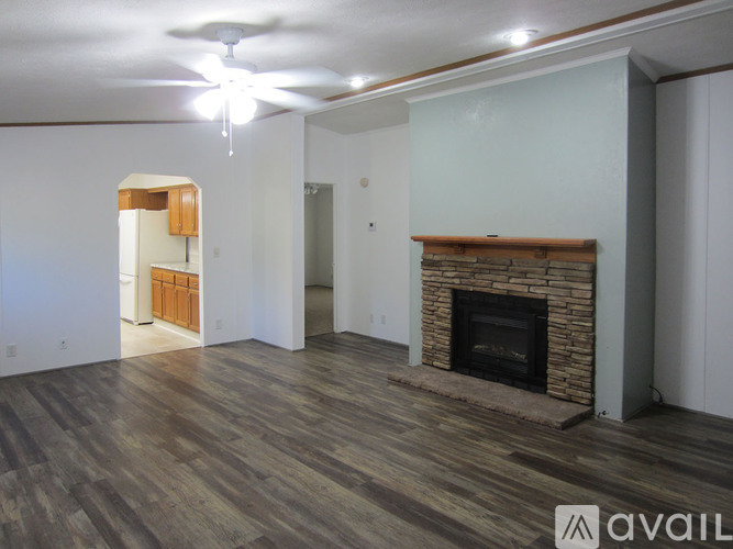 A living room with a fireplace and wood flooring.