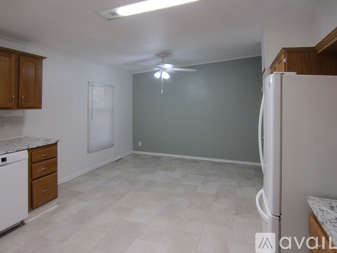 A kitchen with a white fridge, dishwasher and cabinets.