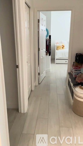 A hallway with a tiled floor and white walls.