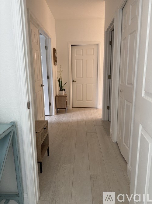 A dog is sitting on a white couch in a living room.