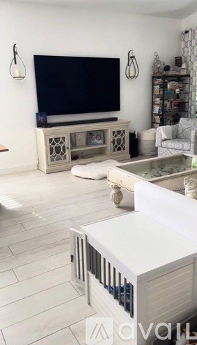 A white entertainment center with a television on top of it.