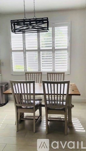 A dining room with a table and chairs.