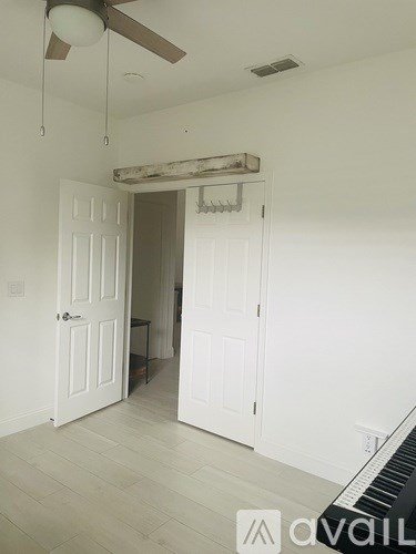 A room with a piano and a ceiling fan.