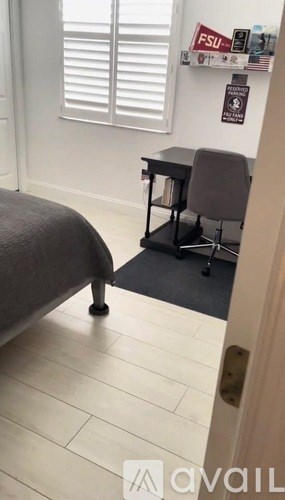A room with a bed, desk, and chair.