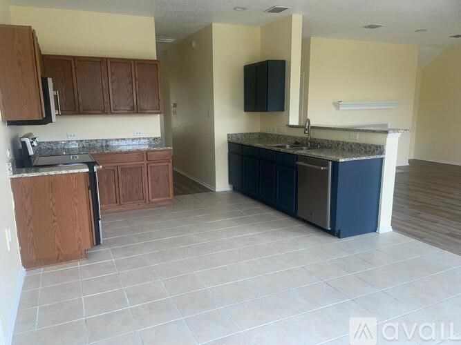 A kitchen with wooden cabinets and a blue island.