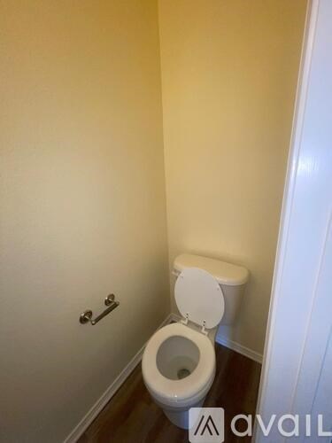 A white toilet in a small bathroom with a white door.