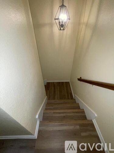 A staircase with wooden steps and a light hanging from the ceiling.