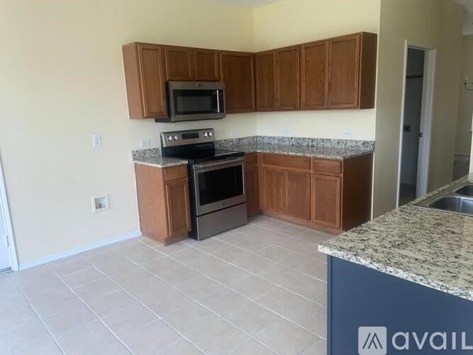 A kitchen with wooden cabinets and granite countertops.