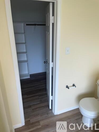 A white toilet is in a small room with a white door.