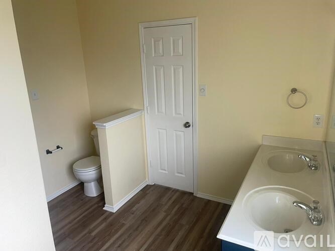 A bathroom with a toilet, sink, and door.