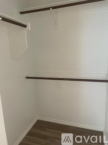 A room with two empty shelves and a wooden floor.