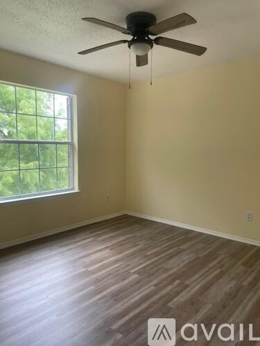A room with a ceiling fan and a window.