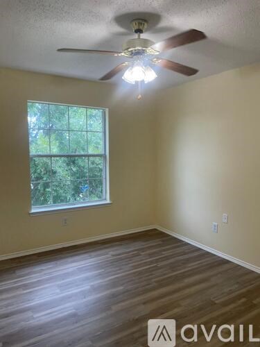A room with a ceiling fan and wooden flooring.