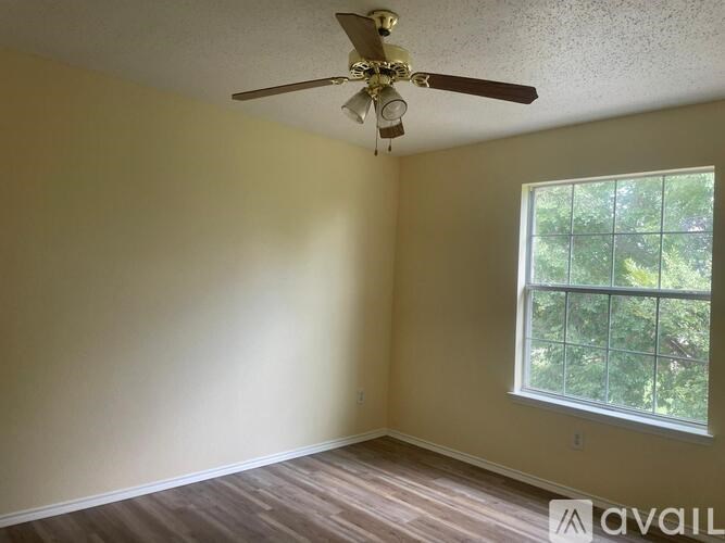 A room with a ceiling fan and a window.