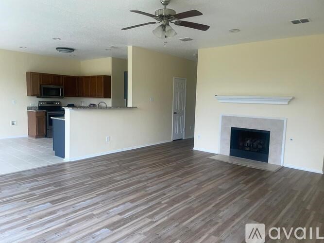 A living room with a fireplace and a ceiling fan.