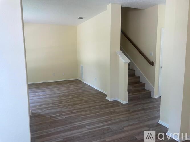 A room with wooden flooring and a staircase.