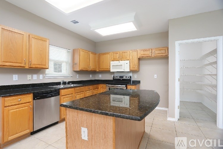 A kitchen with wooden cabinets and a black countertop.