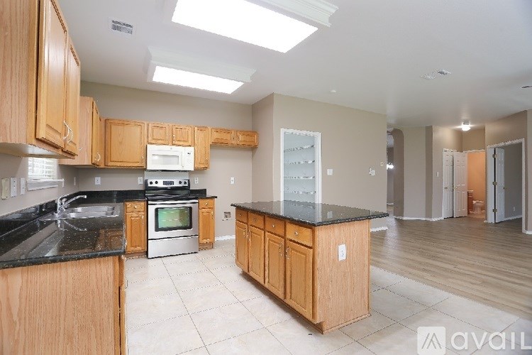 A kitchen with wooden cabinets and a black countertop.