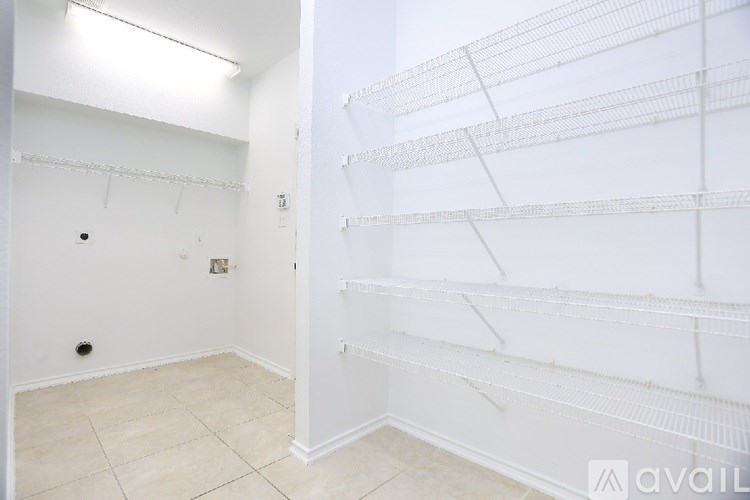 Empty room with white shelves and tiled floor.