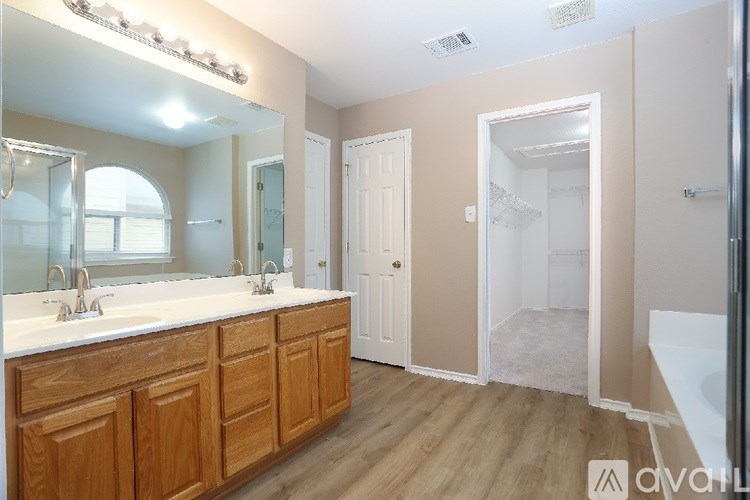 A bathroom with wooden cabinets and a large mirror.