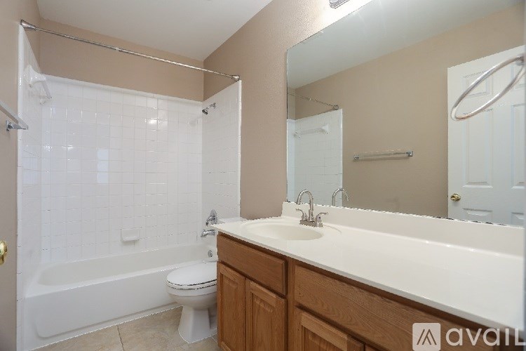 A bathroom with a white tub, sink, and toilet.