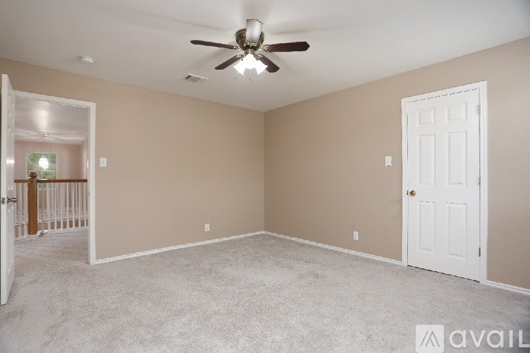 A room with a ceiling fan and two doors.