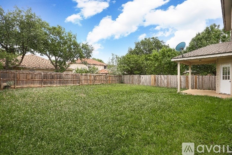 A backyard with a fence and a small house.