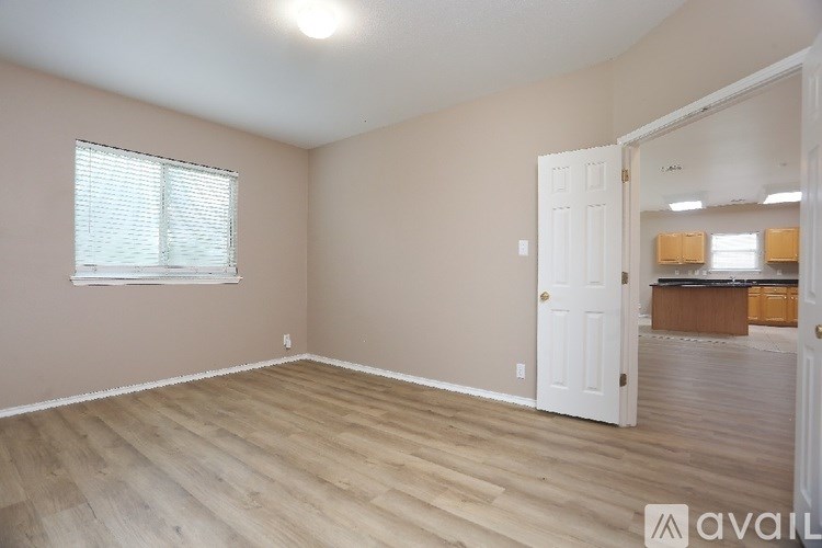 A room with wooden flooring and a white door.