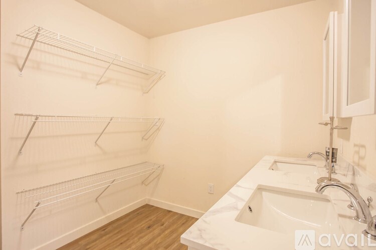 A bathroom with a white sink and empty shelves.