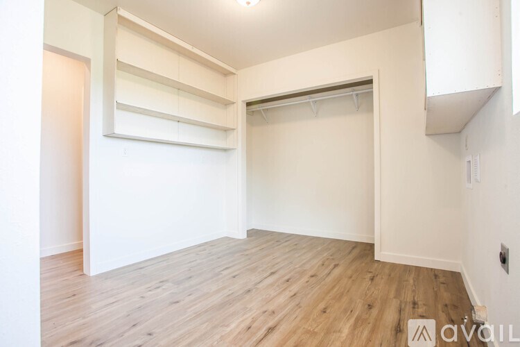 A room with wooden flooring and white walls.