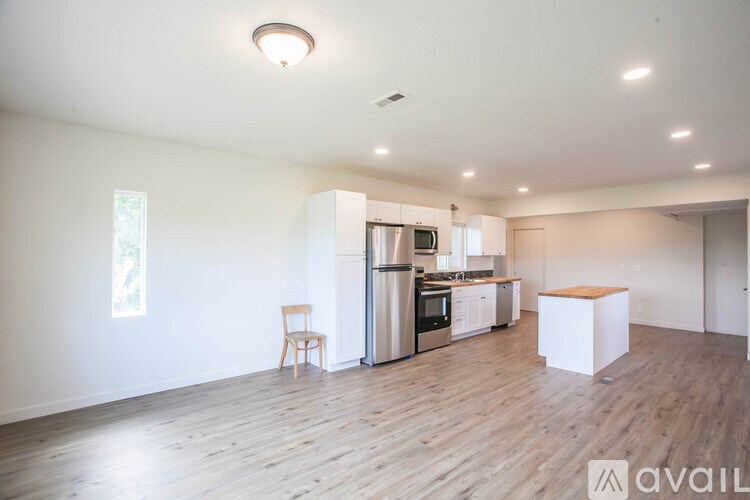 A kitchen with wooden floors and white walls.