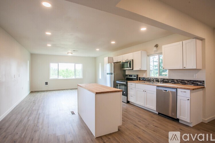 A kitchen with white cabinets and a wooden island.