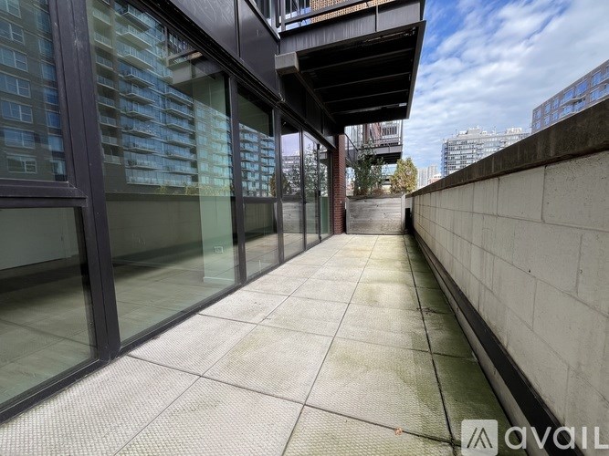 A long, narrow walkway with glass walls on one side and a concrete wall on the other.
