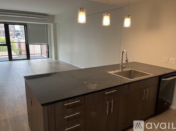 A kitchen with a black countertop and brown cabinets.