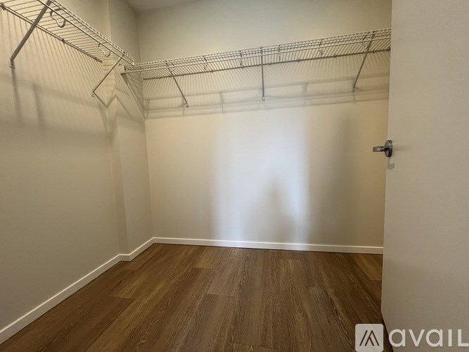 A long hallway with mailboxes on the wall and a door at the end.