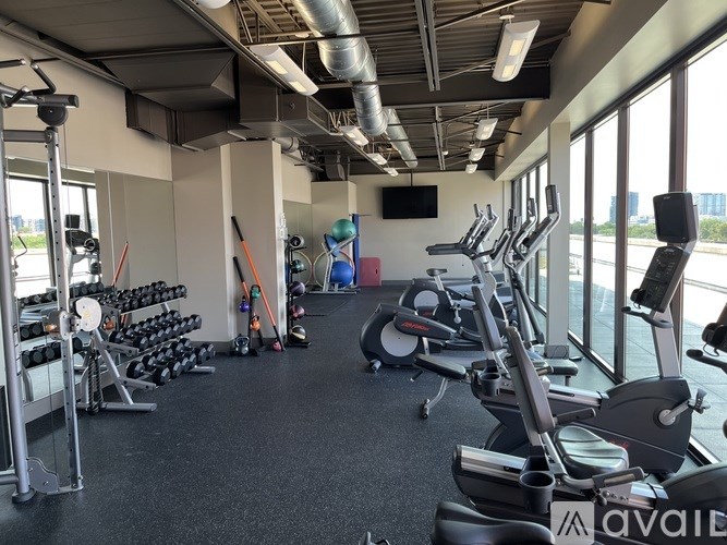 A gym with a variety of equipment including treadmills, weights, and exercise machines.