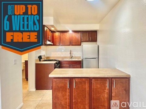 A kitchen with brown cabinets and a white refrigerator is on sale for up to 6 weeks free.