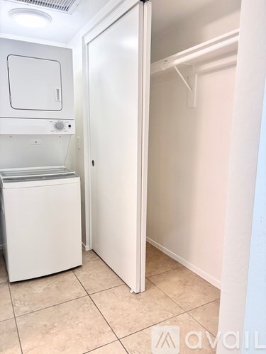 A small white kitchen with a dishwasher and a refrigerator.