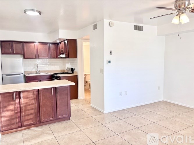 A kitchen with brown cabinets and a white refrigerator.