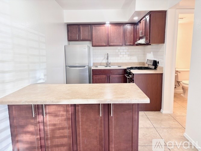 A kitchen with brown cabinets and a marble countertop.