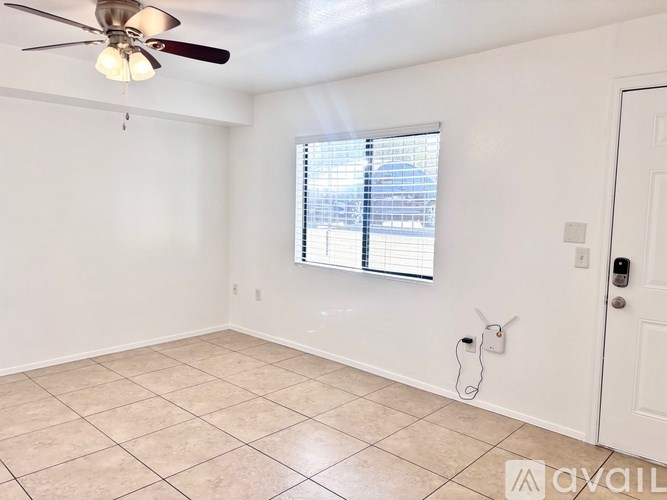 A room with a ceiling fan and a window with blinds.