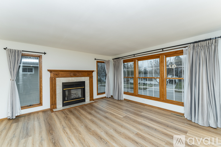 A spacious room with a fireplace and large windows.