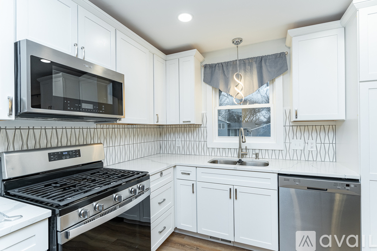 A kitchen with white cabinets and a black stove top oven.
