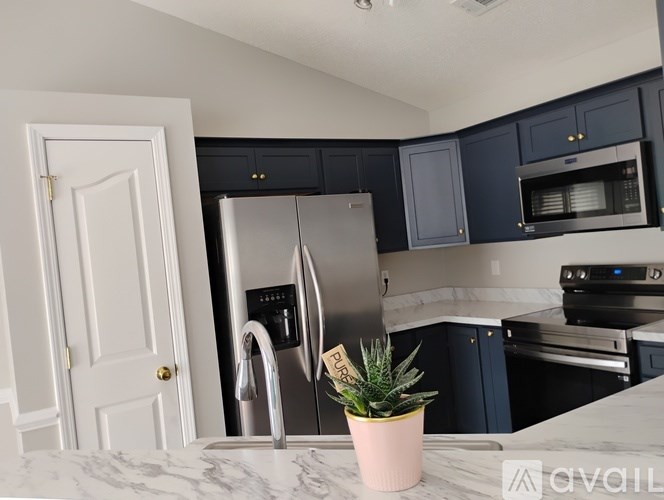 A kitchen with a refrigerator, stove, and microwave.