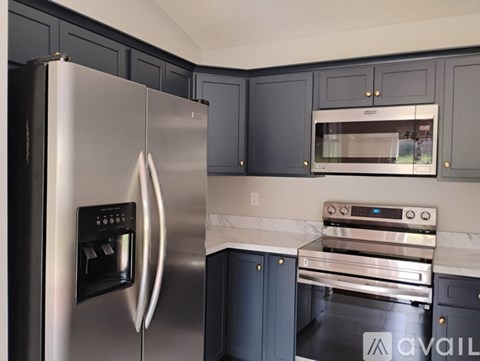 A modern kitchen with a stainless steel refrigerator and microwave.