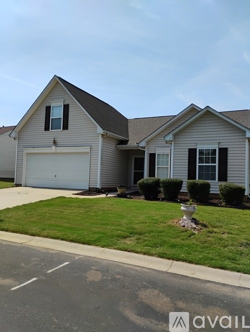 A house with a grey roof and a white garage door.