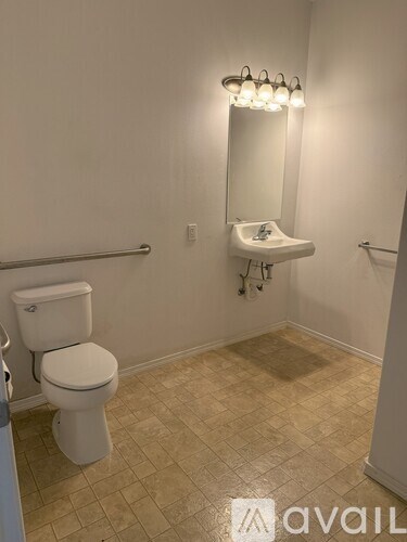 A white toilet in a bathroom with a sink and mirror.
