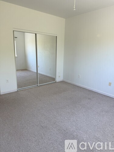A room with a carpeted floor and a sliding glass door.